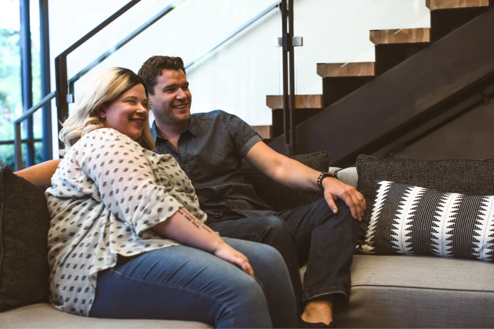 man and woman watching tv on the couch together